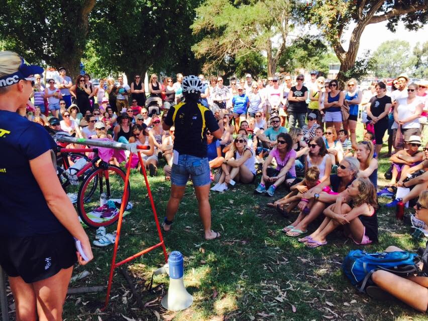 A large group of athletes listening to a Tri Alliance bike and race-skills briefing