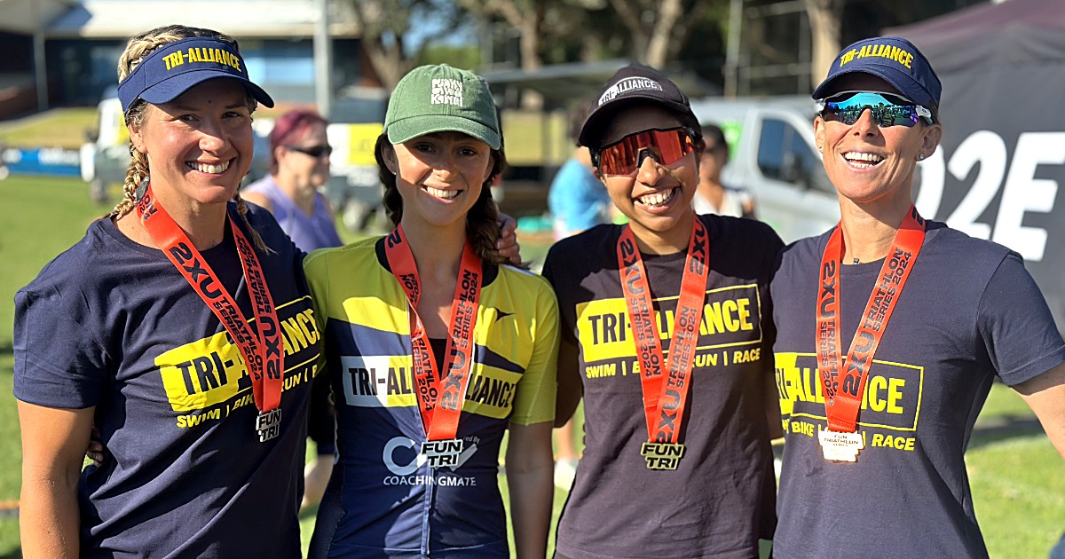 Four Tri Alliance women smiling with their race medals