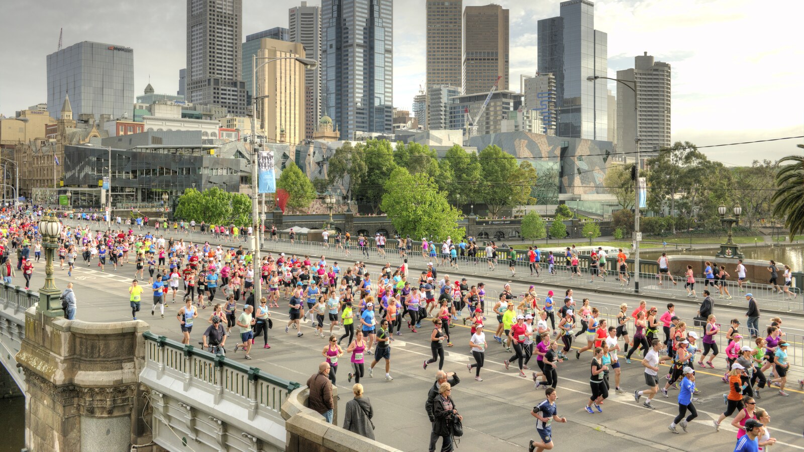 Melbourne Marathon runners crossing Princes Bridge with the Melbourne skyline behind them